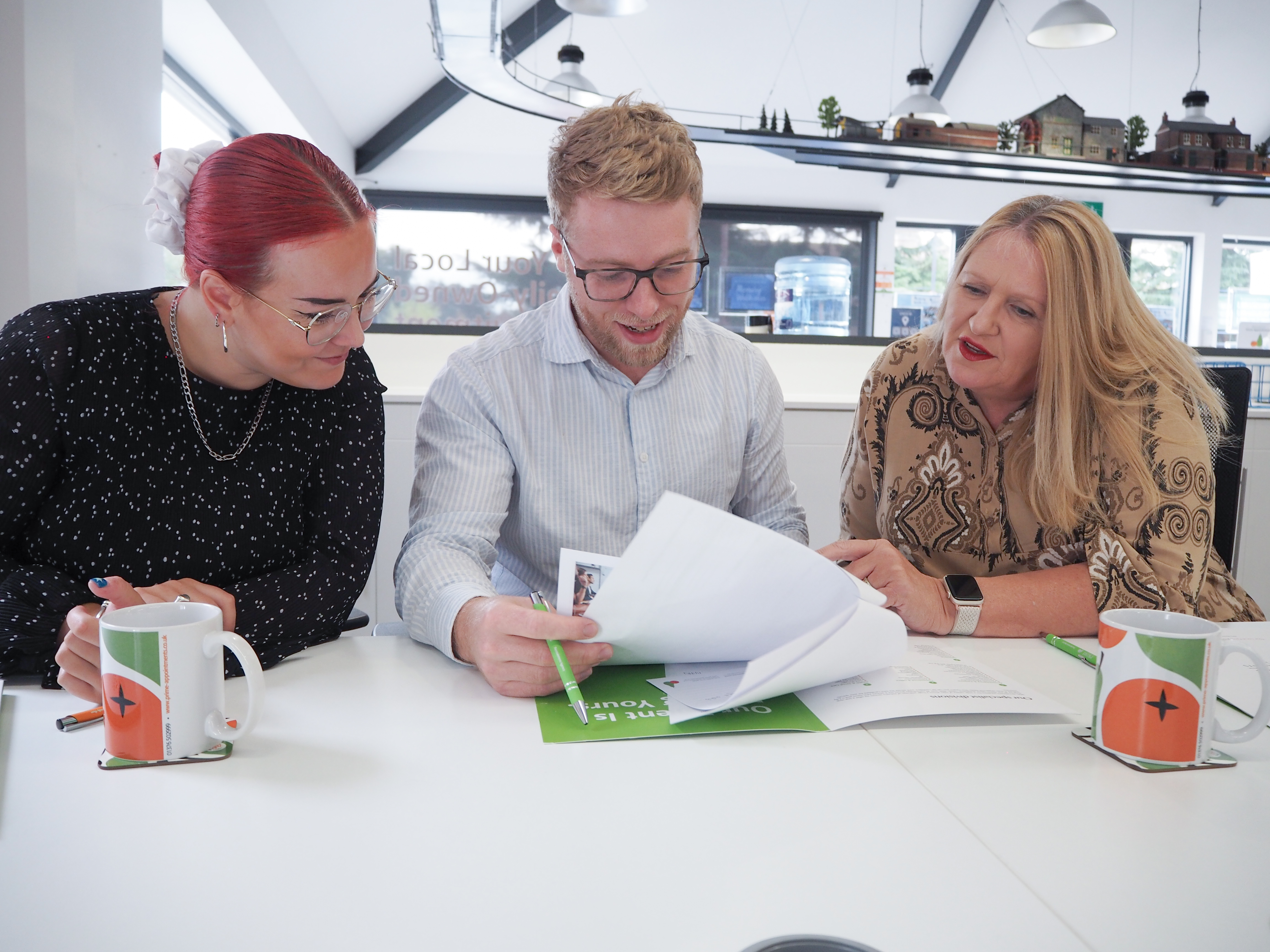 Recruitment consultants Helen, Carl and Louise flicking through paperwork.