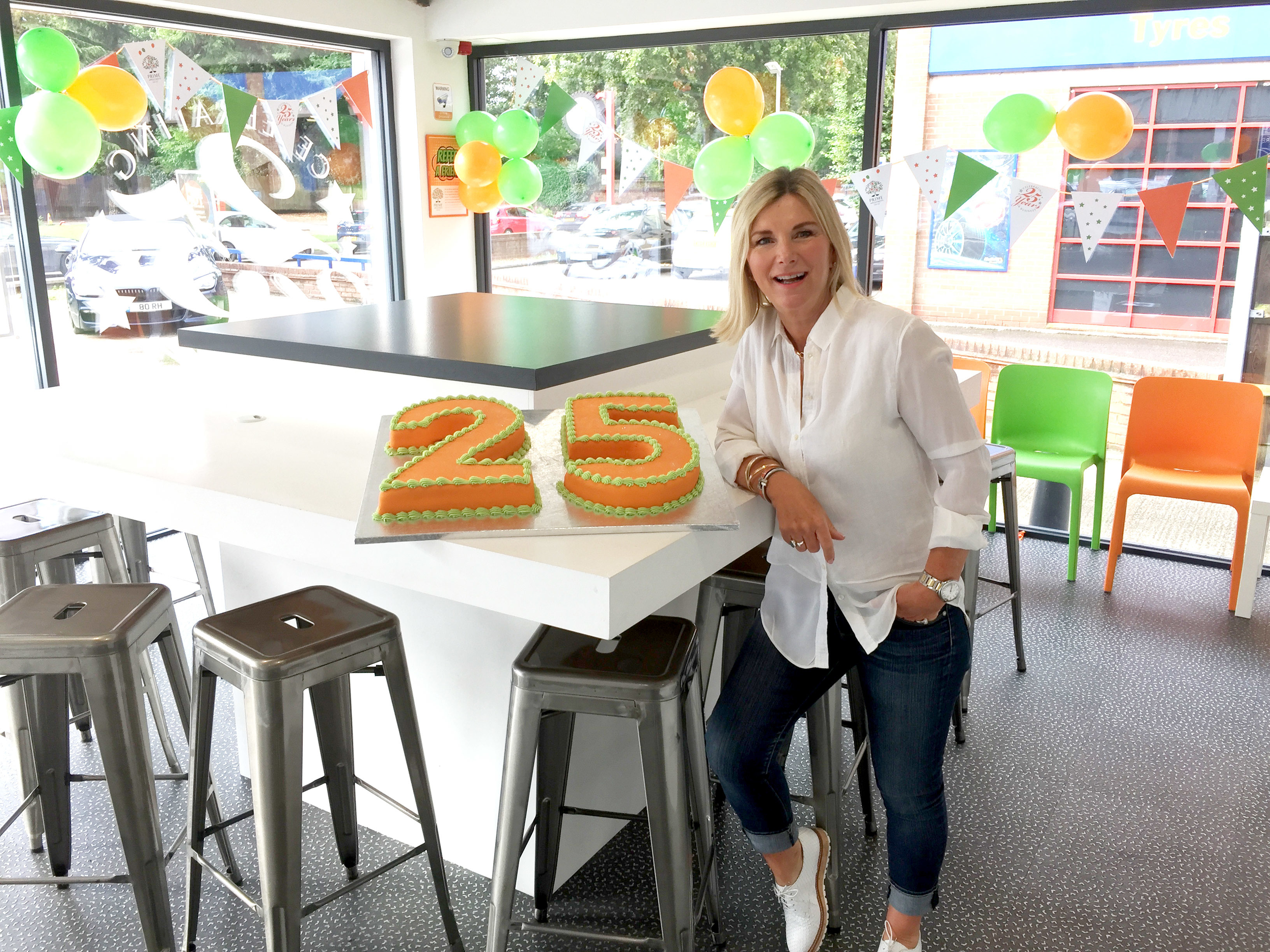 Robyn Holmes, MD of Prime Appointments, celebrating 25 years in business with cake in reception at Witham office