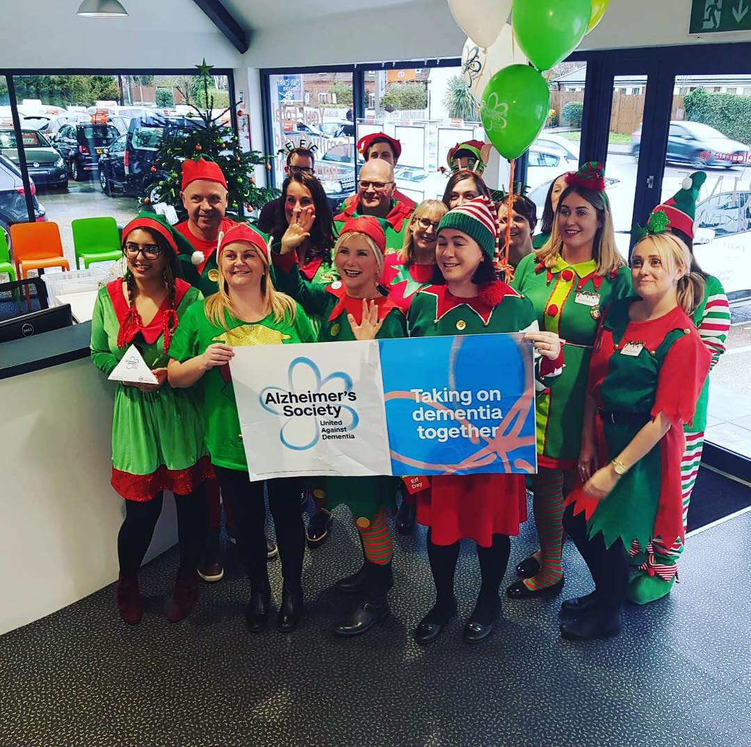 Elf Day 2018 for Alzheimers, everyone dressed at Elfs and holding Alzheimers banner up 3