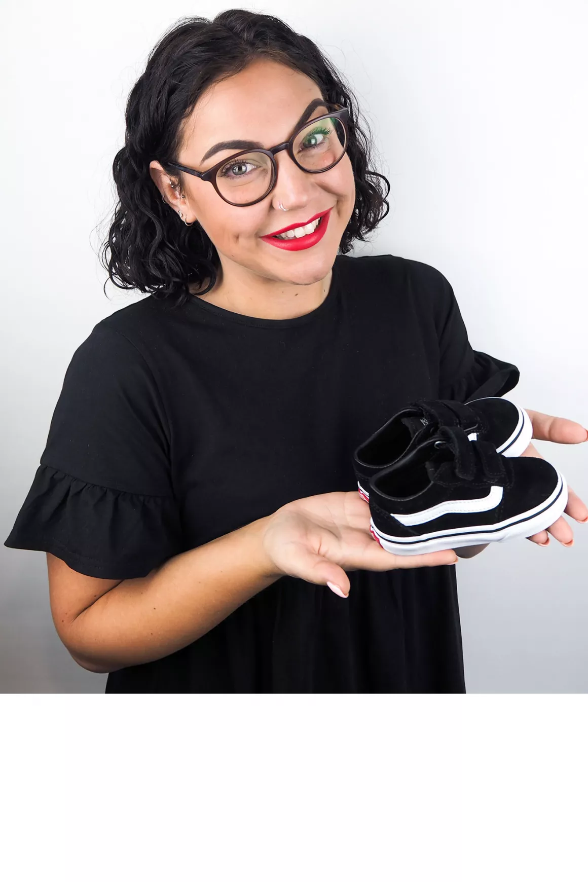 Storme White (Design Executive) wearing black glasses & black top, holding her daughters shoes in photo, taken at Prime Appointments HQ in Witham